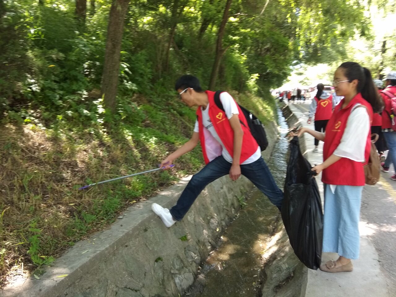 新浦京学生正在开展净化文化遗产景区环境志愿服务活动