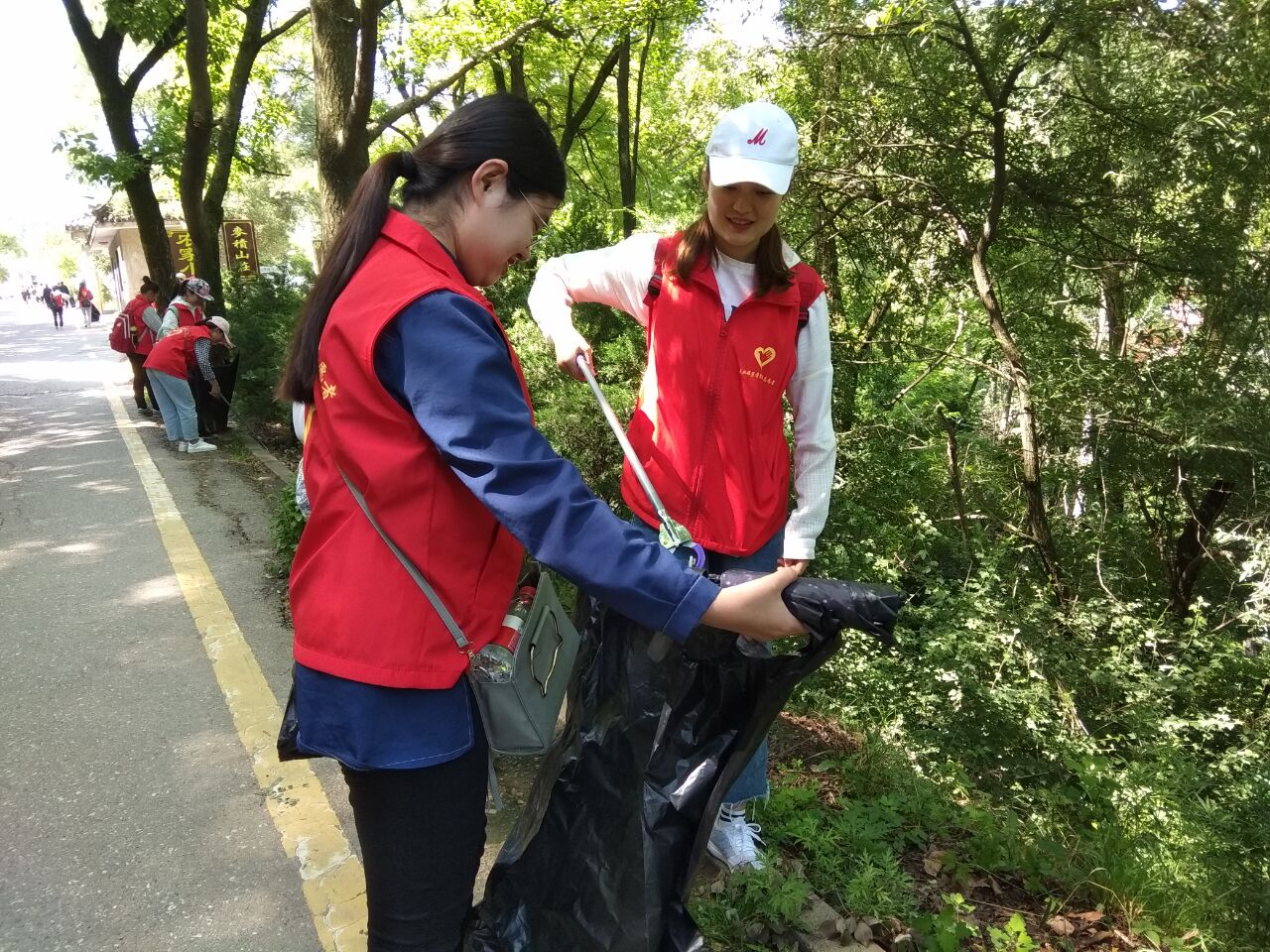 新浦京学生正在开展净化文化遗产景区环境志愿服务活动